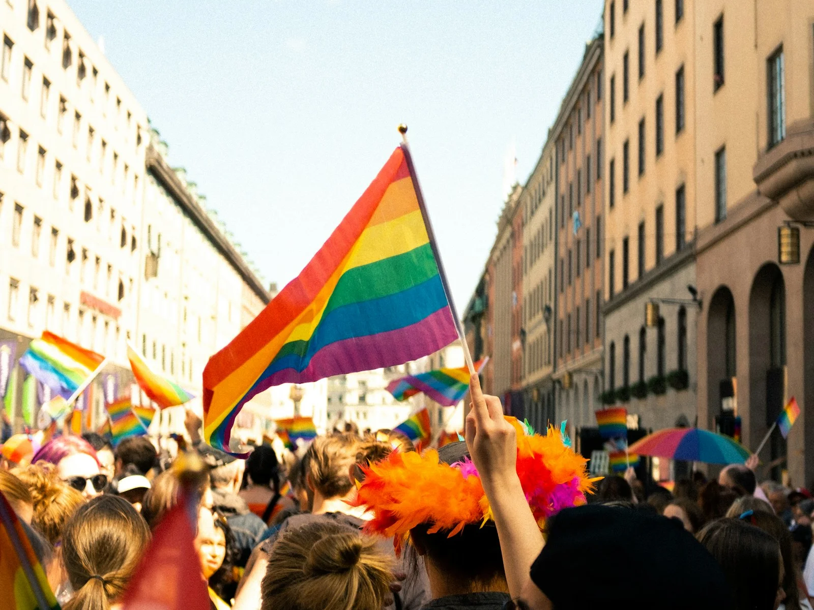 LGBTQ+ travellers gathering with Pride flags