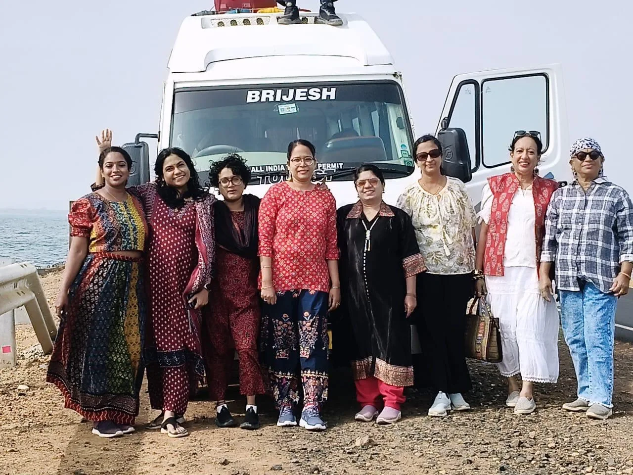 A group of travelers beside their tour van
