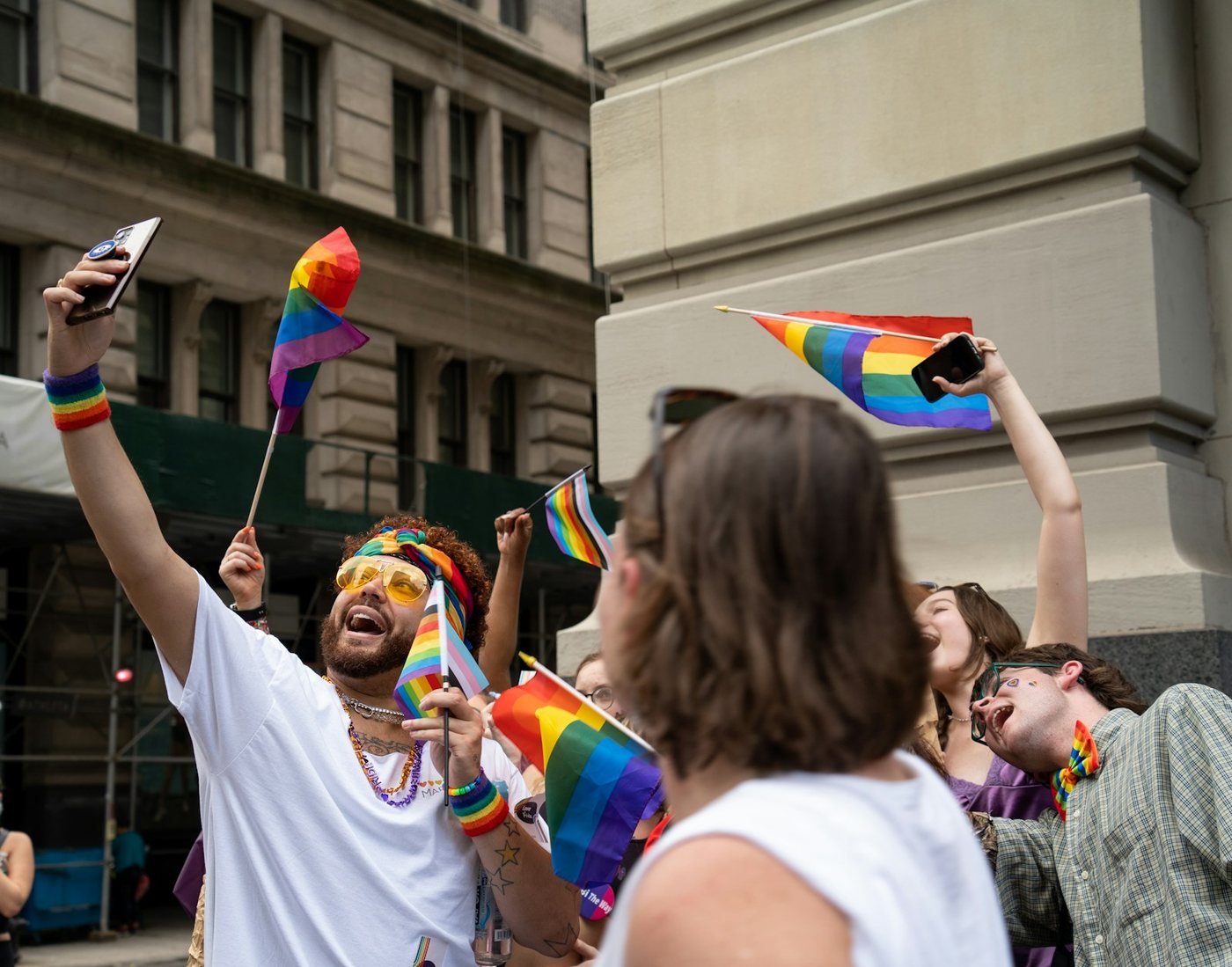 Diverse LGBTQ friends group traveling in vibrant cities