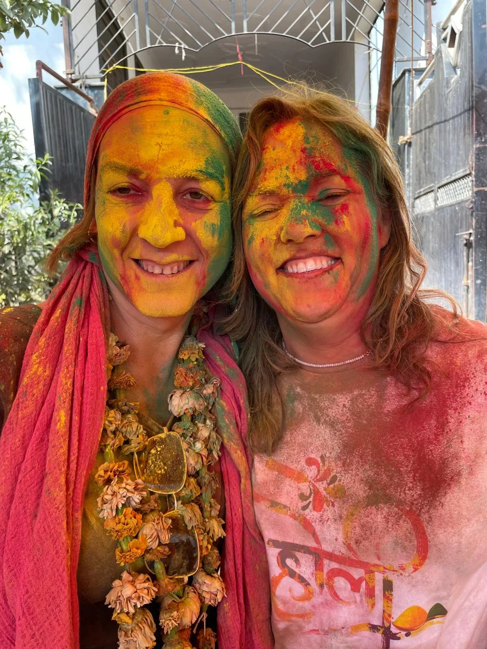 Two travelers with colourful Holi powder on their faces